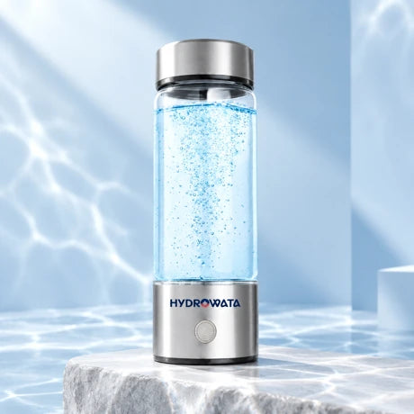 Hydrowata glass hydrogen water bottle on a pale stone plinth
